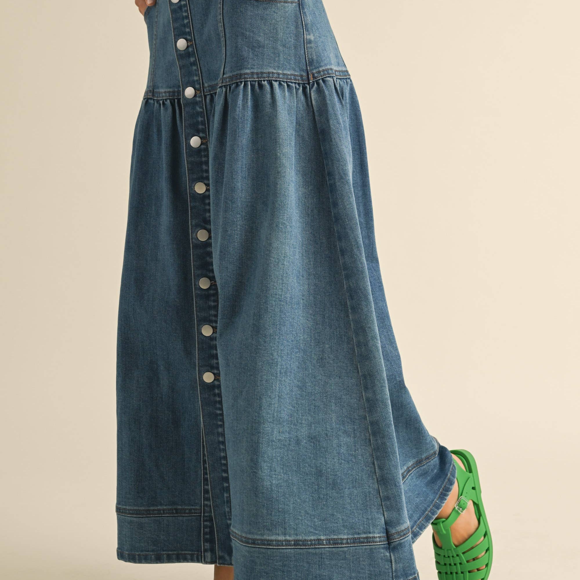 Crafted from classic denim, it features a charming front button closure that adds personality