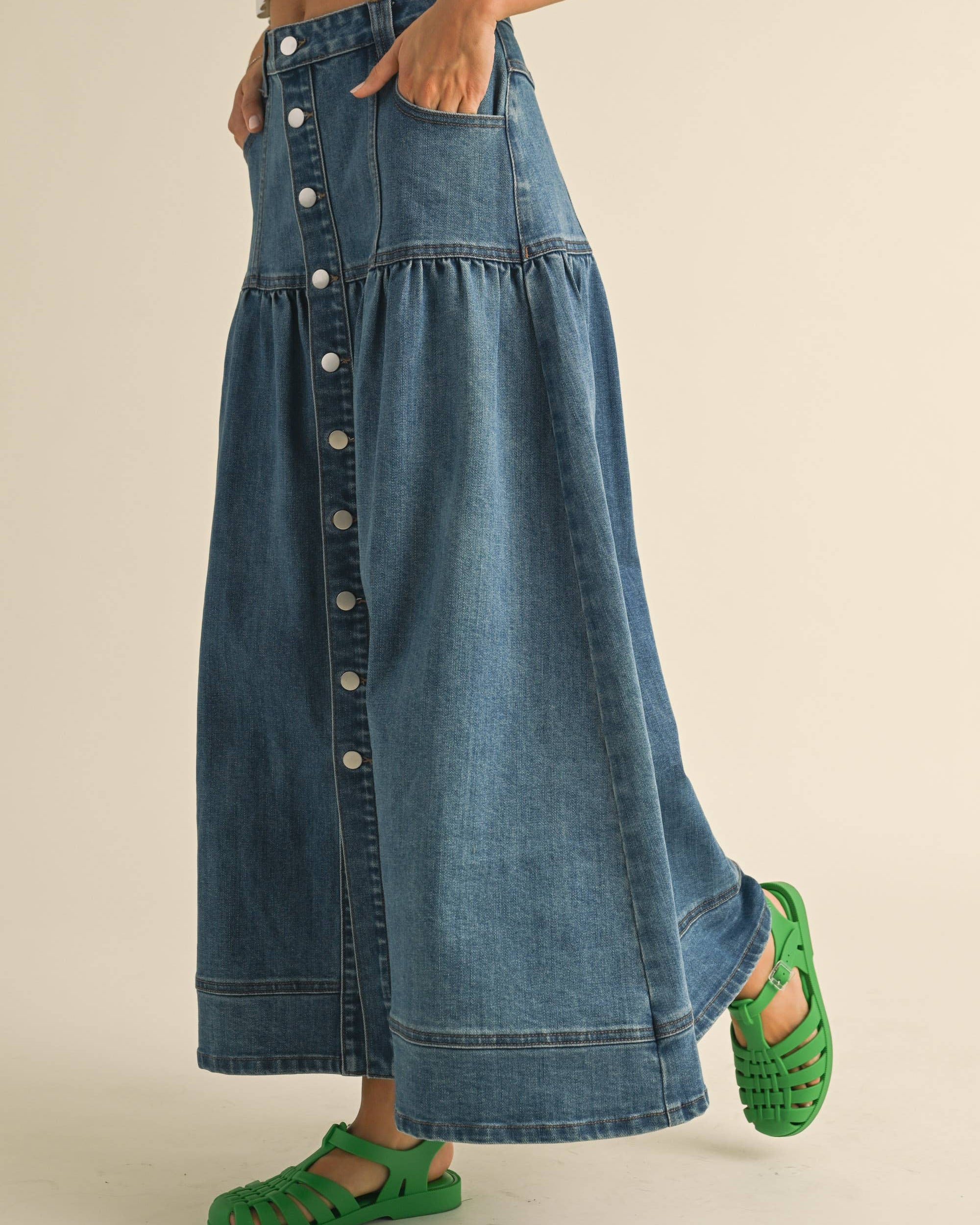Crafted from classic denim, it features a charming front button closure that adds personality