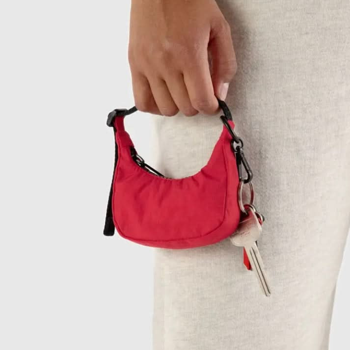 Red keychain pouch held by a hand with a neutral background