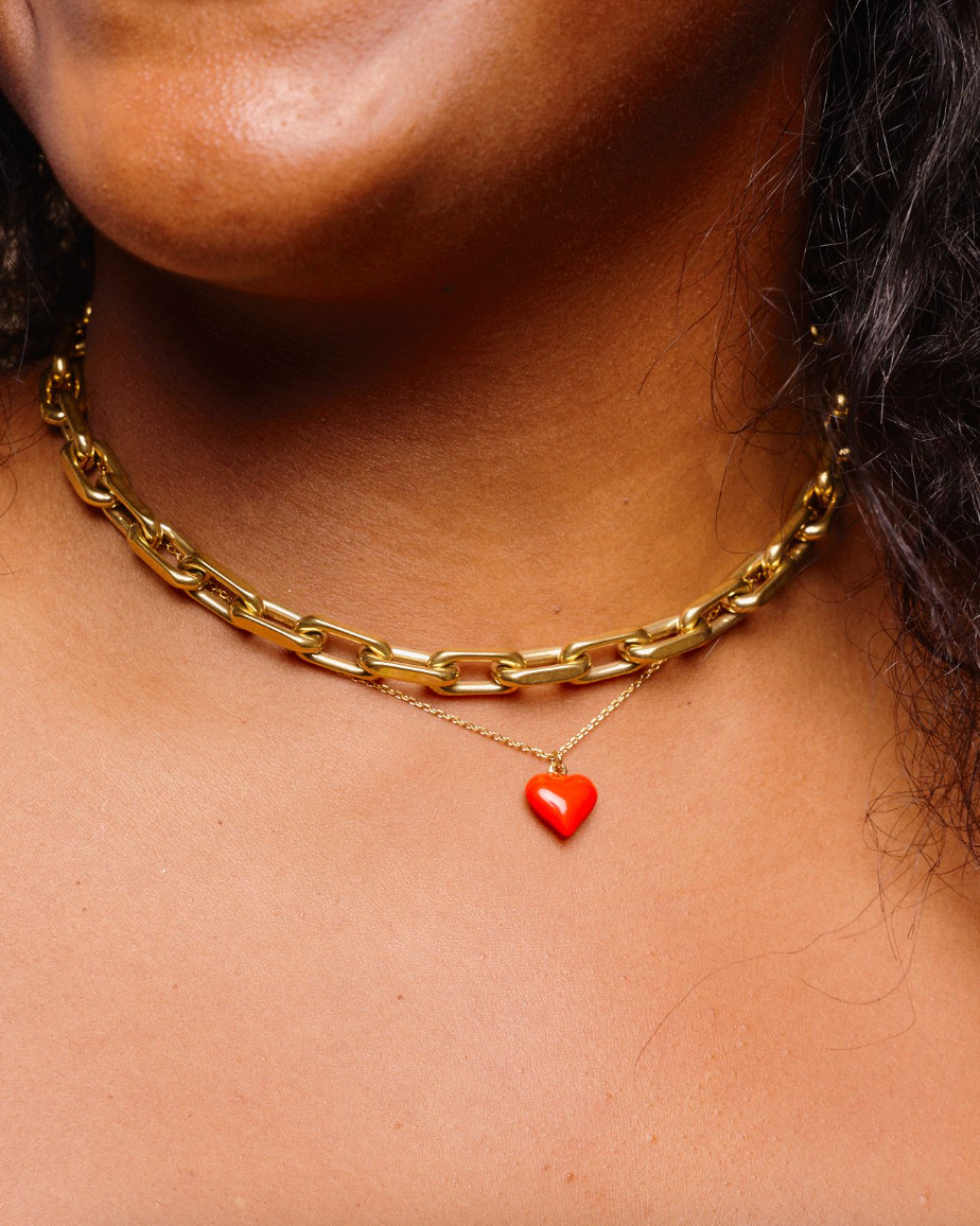 Woman wearing a necklace stack including a gold, waterproof, chunky link choker