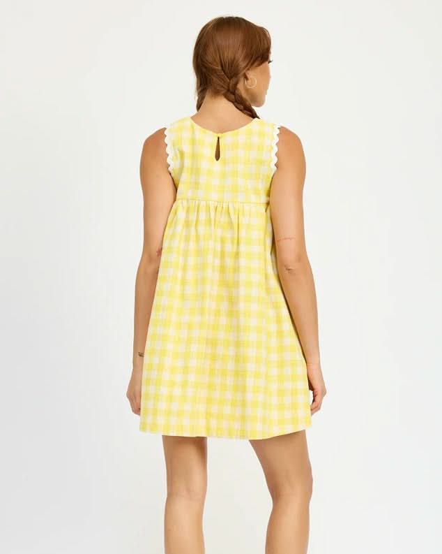 Woman wearing a yellow checkered dress on a white background