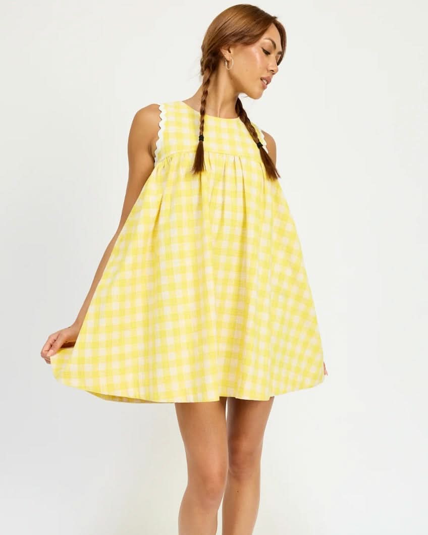 Woman wearing a yellow checkered dress on a white background