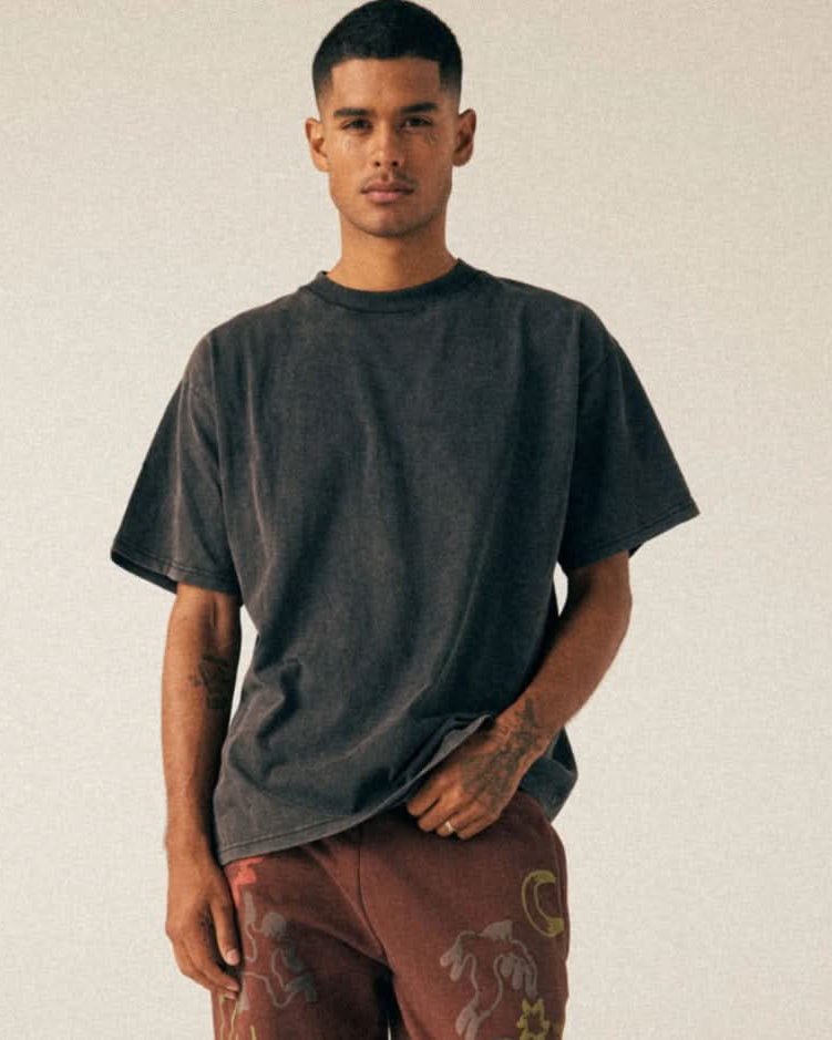 Man wearing black, vintage, washed, oversized, box, tee t-shirts with embroidered brown pants