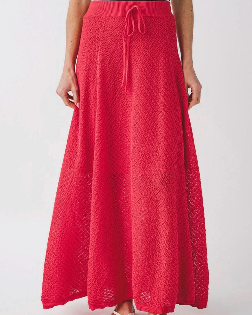 Woman wearing knit red skirt with diamond geometrical pattern and front tie