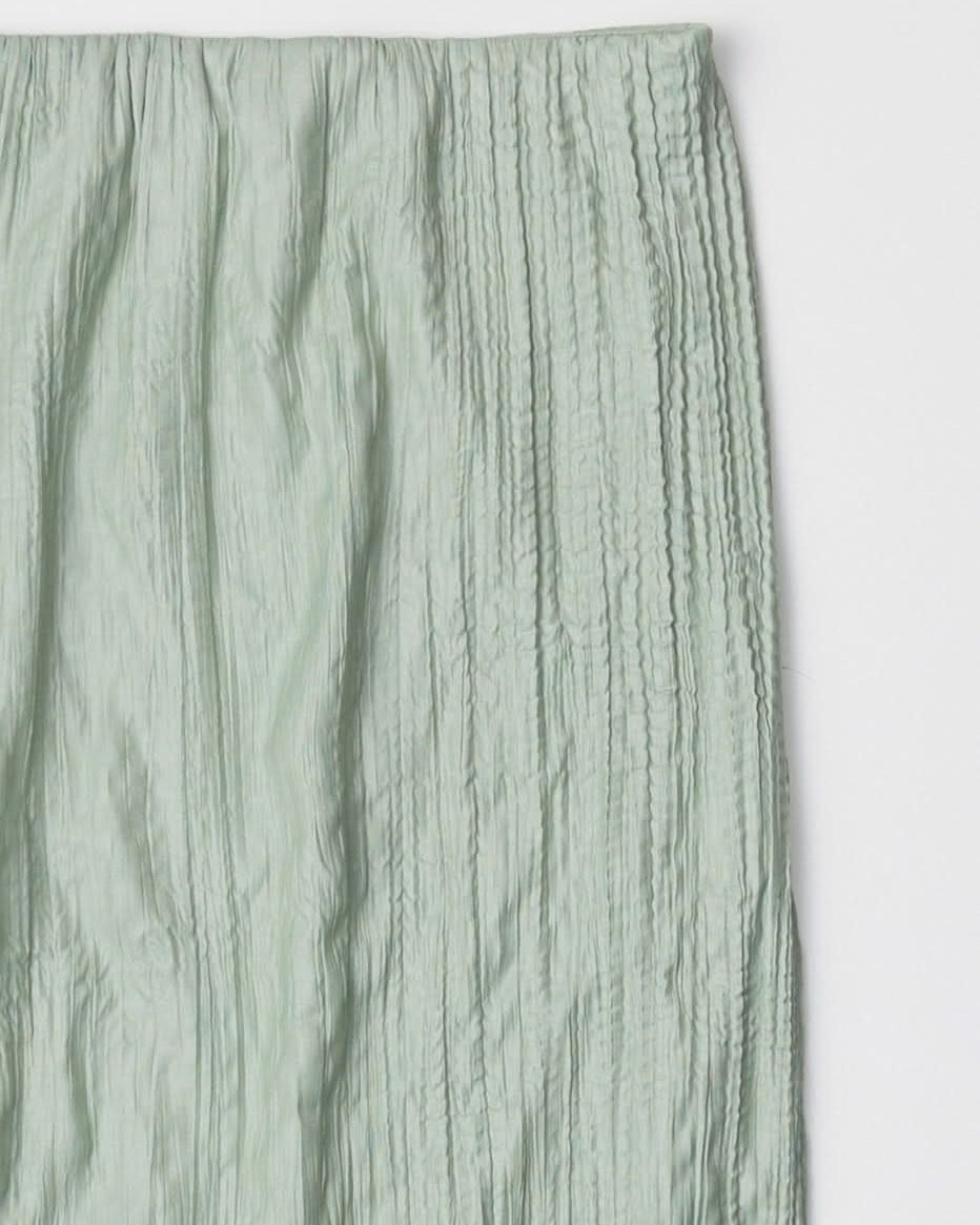 sea foam, Sage green textured skirt laid against a white surface