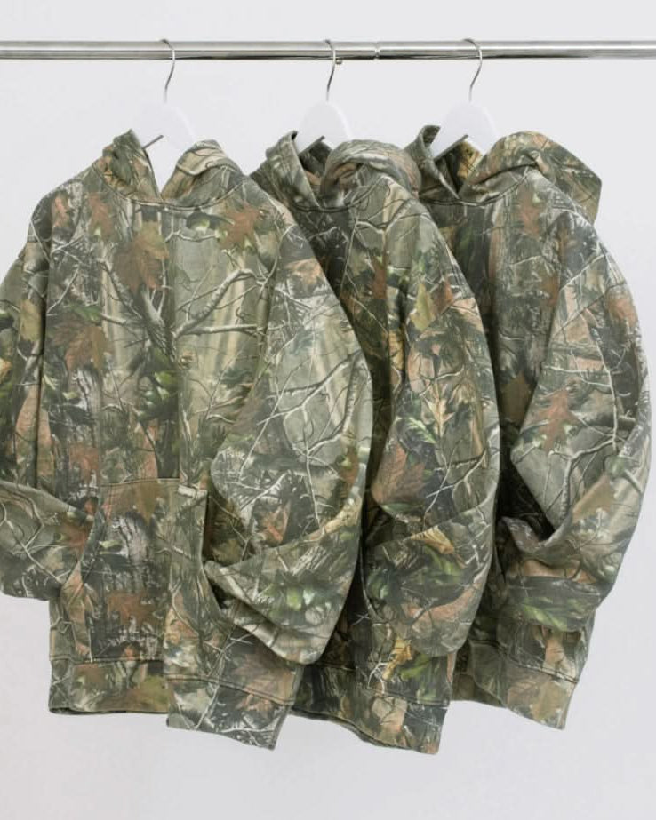 Three Vintage camo real tree cotton pullover hoodie sweatshirts hanging on hangers