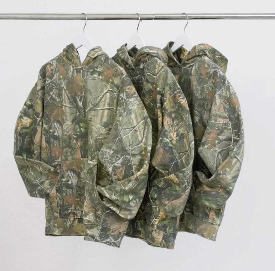 Three Vintage camo real tree cotton pullover hoodie sweatshirts hanging on hangers