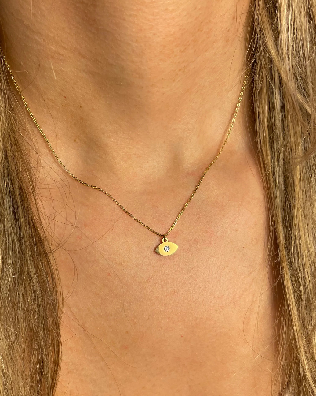 Gold necklace with a small gold eye pendant with diamond.