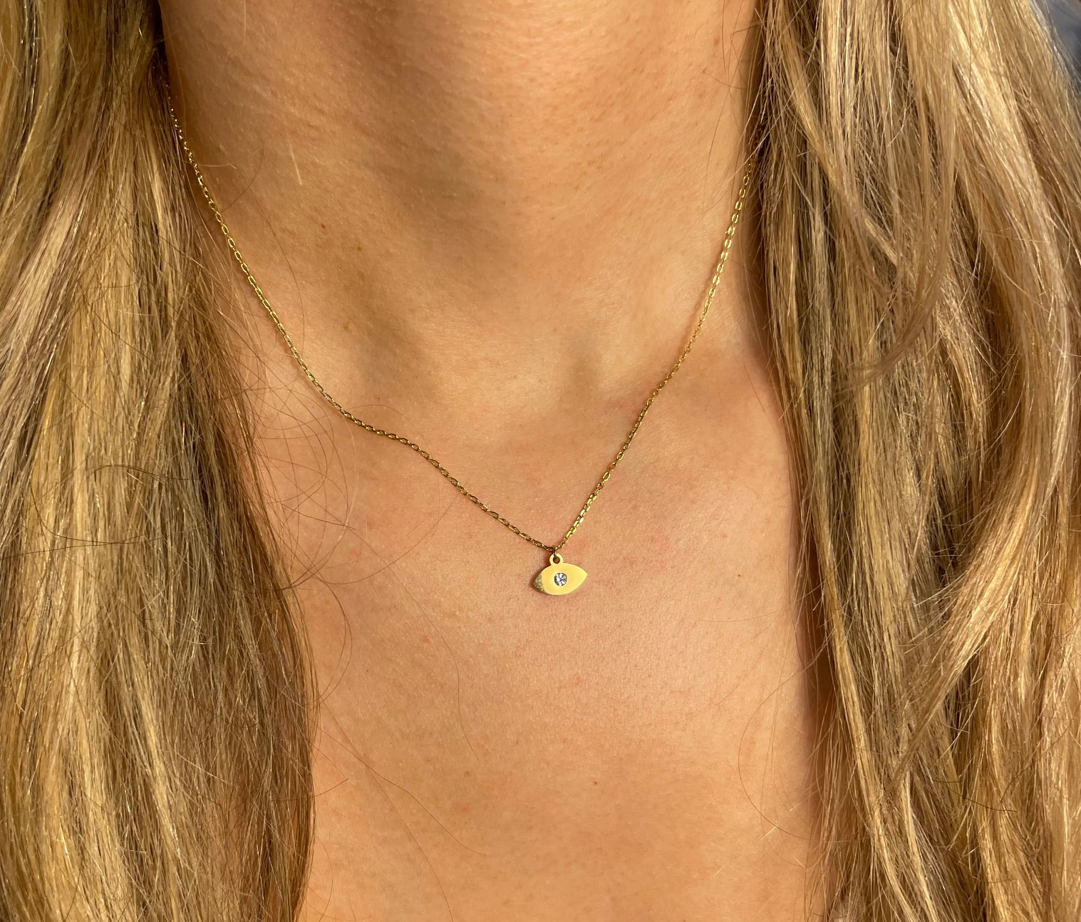 Gold necklace with a small gold eye pendant with diamond.