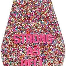 Pink confetti motel keychain that has pink letters that say Strong As Hell