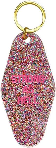 Pink confetti motel keychain that has pink letters that say Strong As Hell