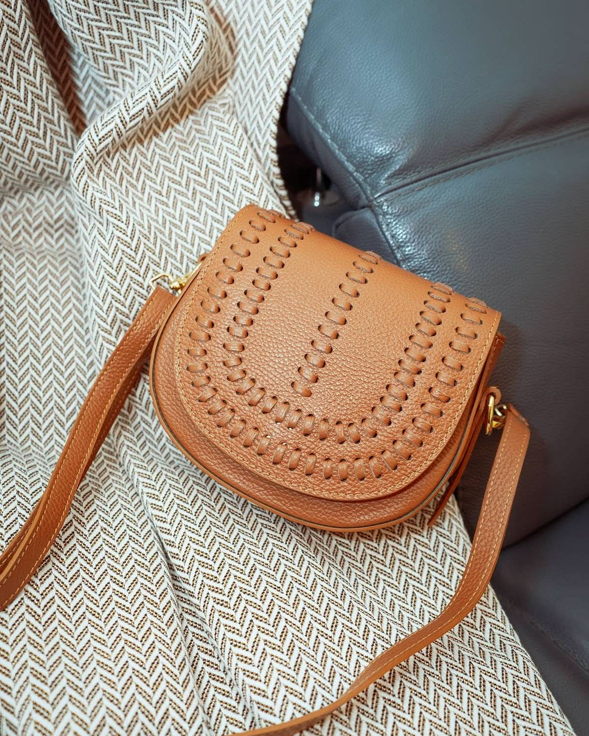 Chestnut brown colored leather crossbody bag with magnetic front clap and leather woven geometric design and gold Metal details