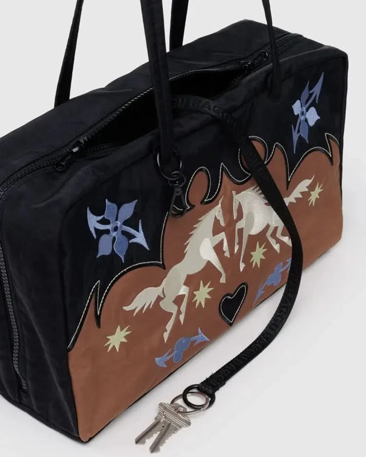 Brown, black, light blue, and white nylon BAGGU western bowler bag. With horses in the front, Four charm loops and a swivel clasp to let you accessorize