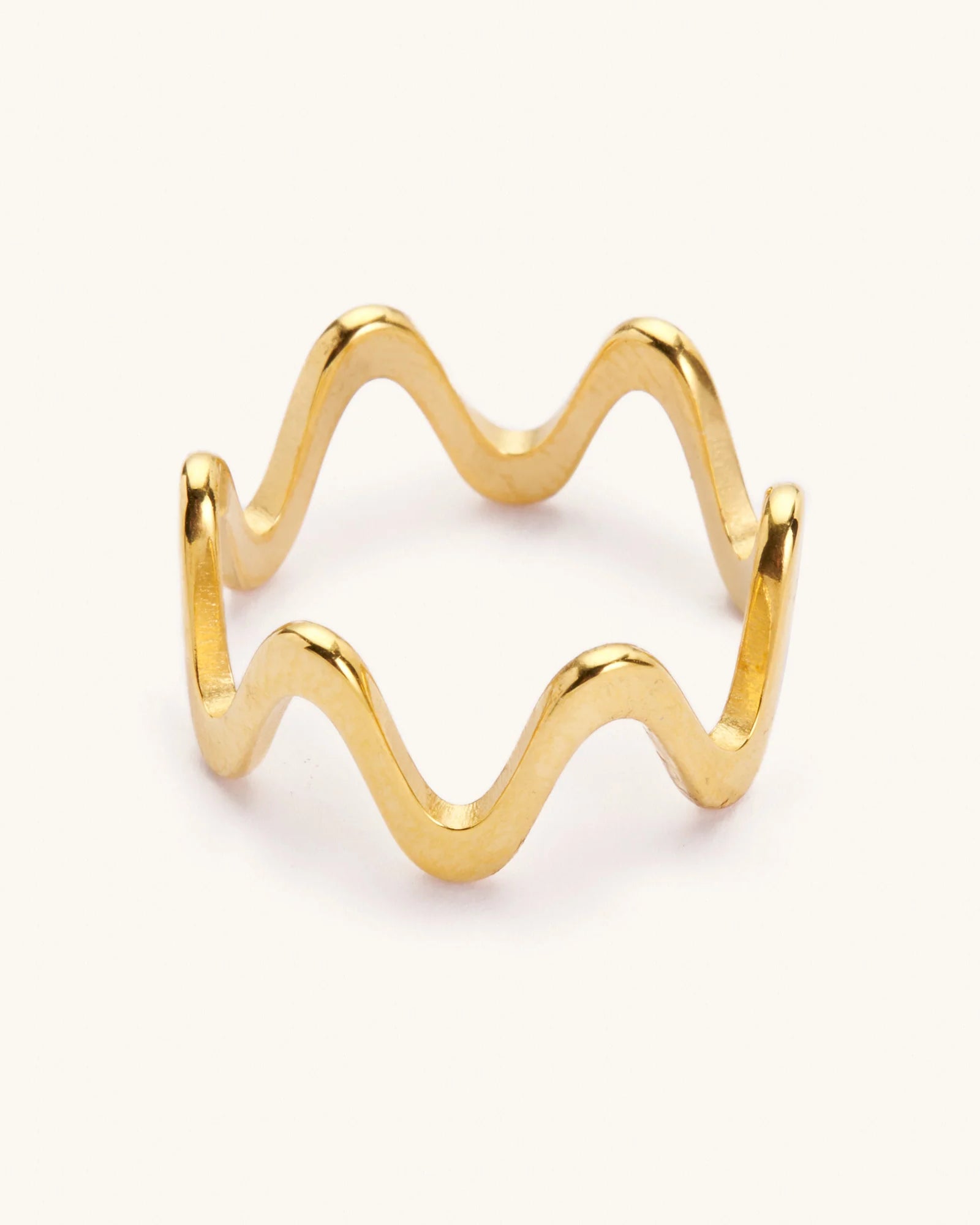 Gold wavy ring laying on a white background