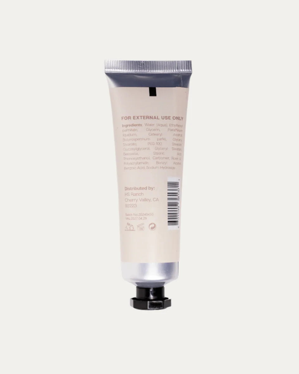 Hand cream tube with silver cap and black base on a light gray background