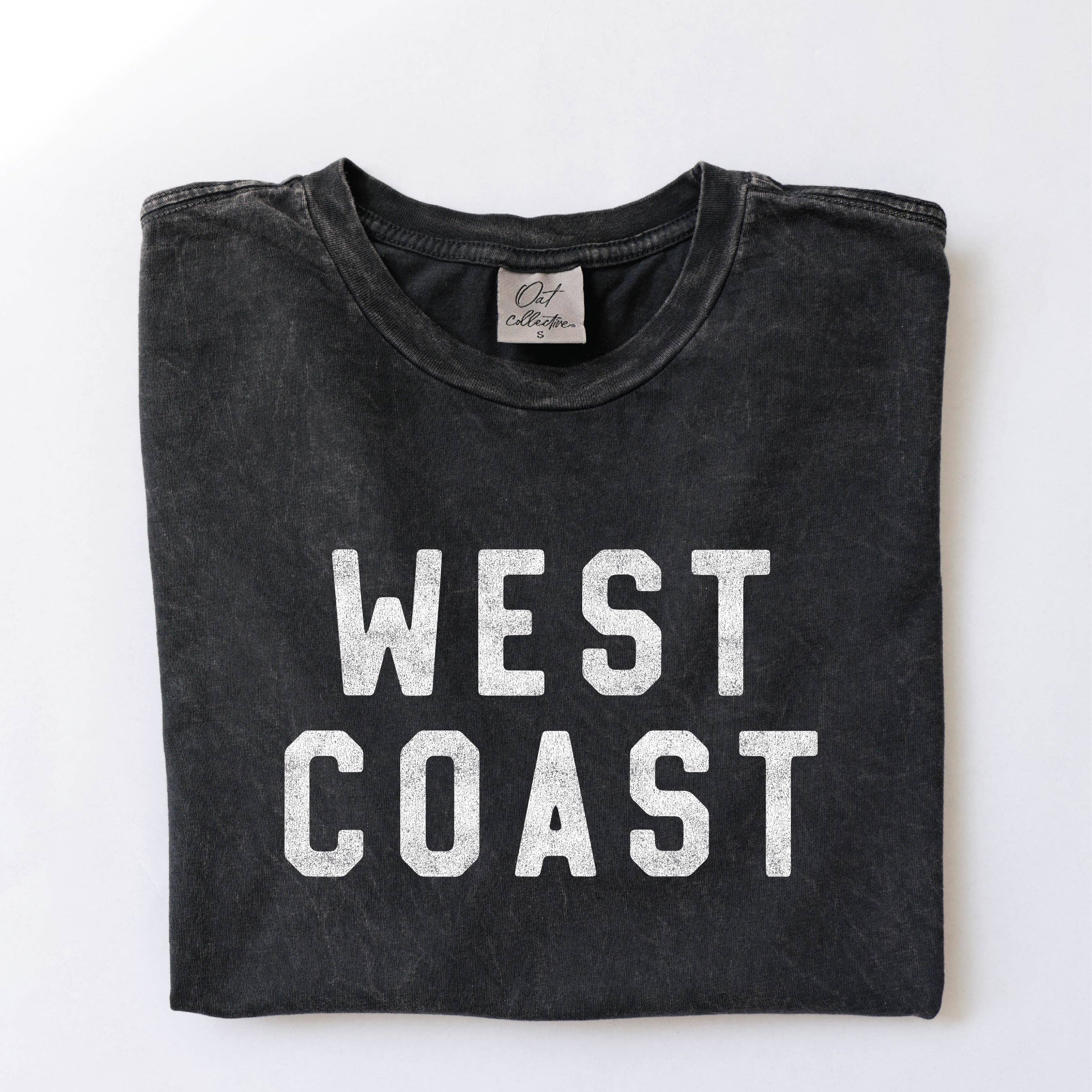 Folded black t-shirt with 'WEST COAST' text on a white background