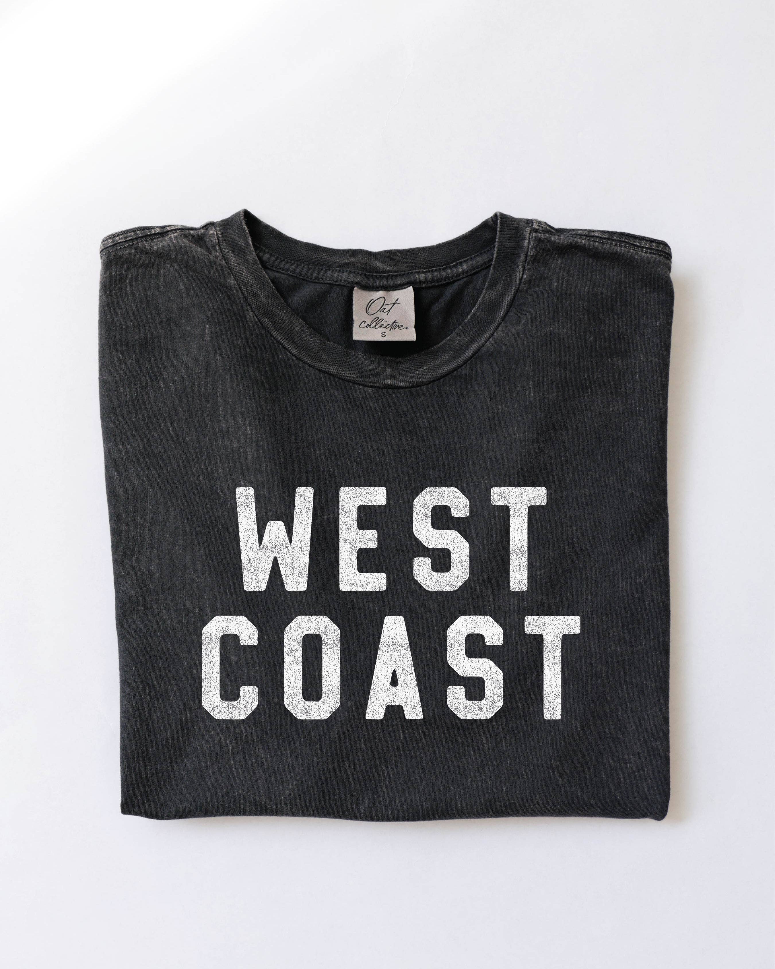 Folded black t-shirt with 'WEST COAST' text on a white background