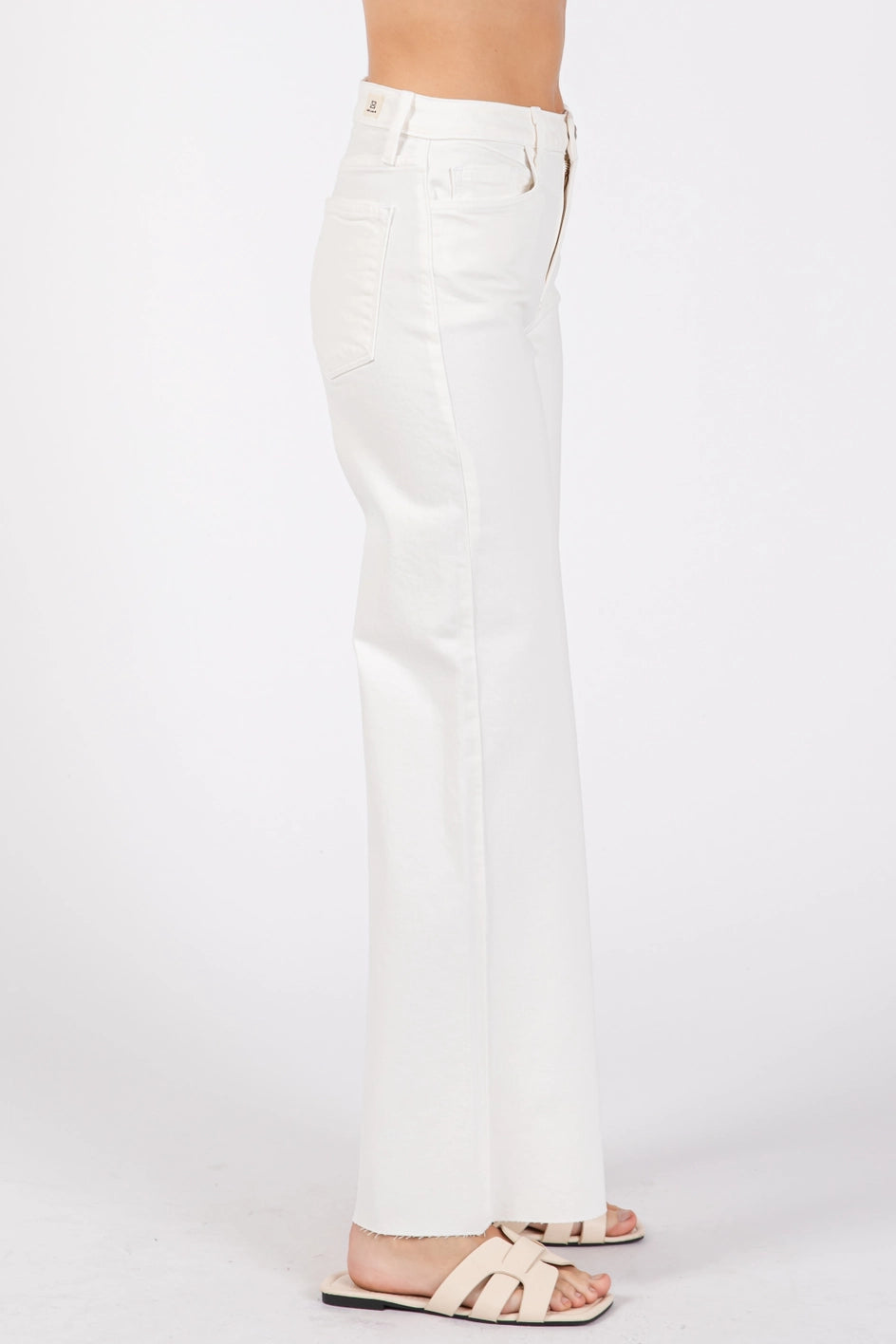 White jeans worn by a person on a white background