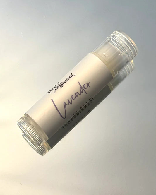 Lip balm stick labeled 'Lavender' on a gradient gray background