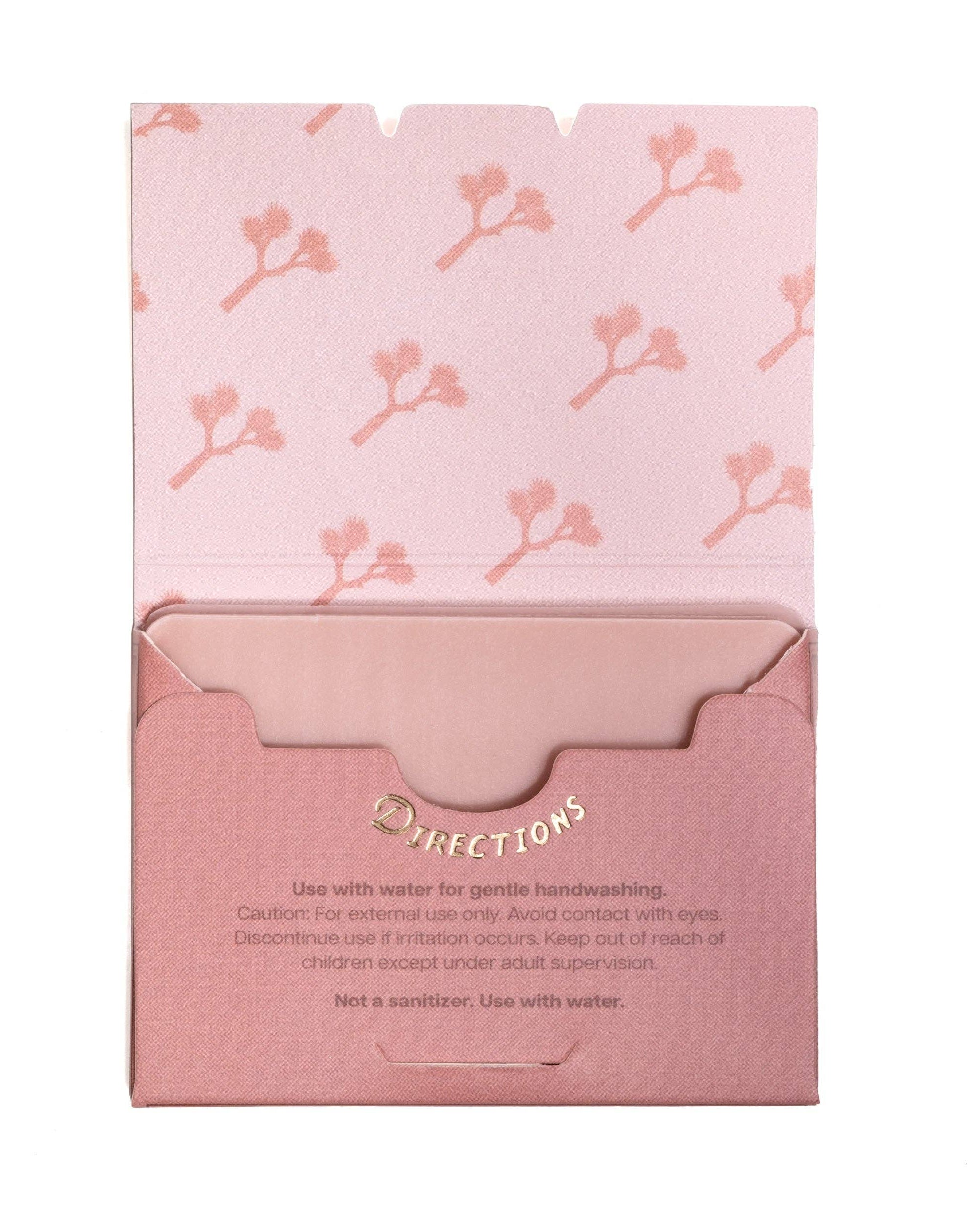 Pink packaging with floral pattern and text on a white background