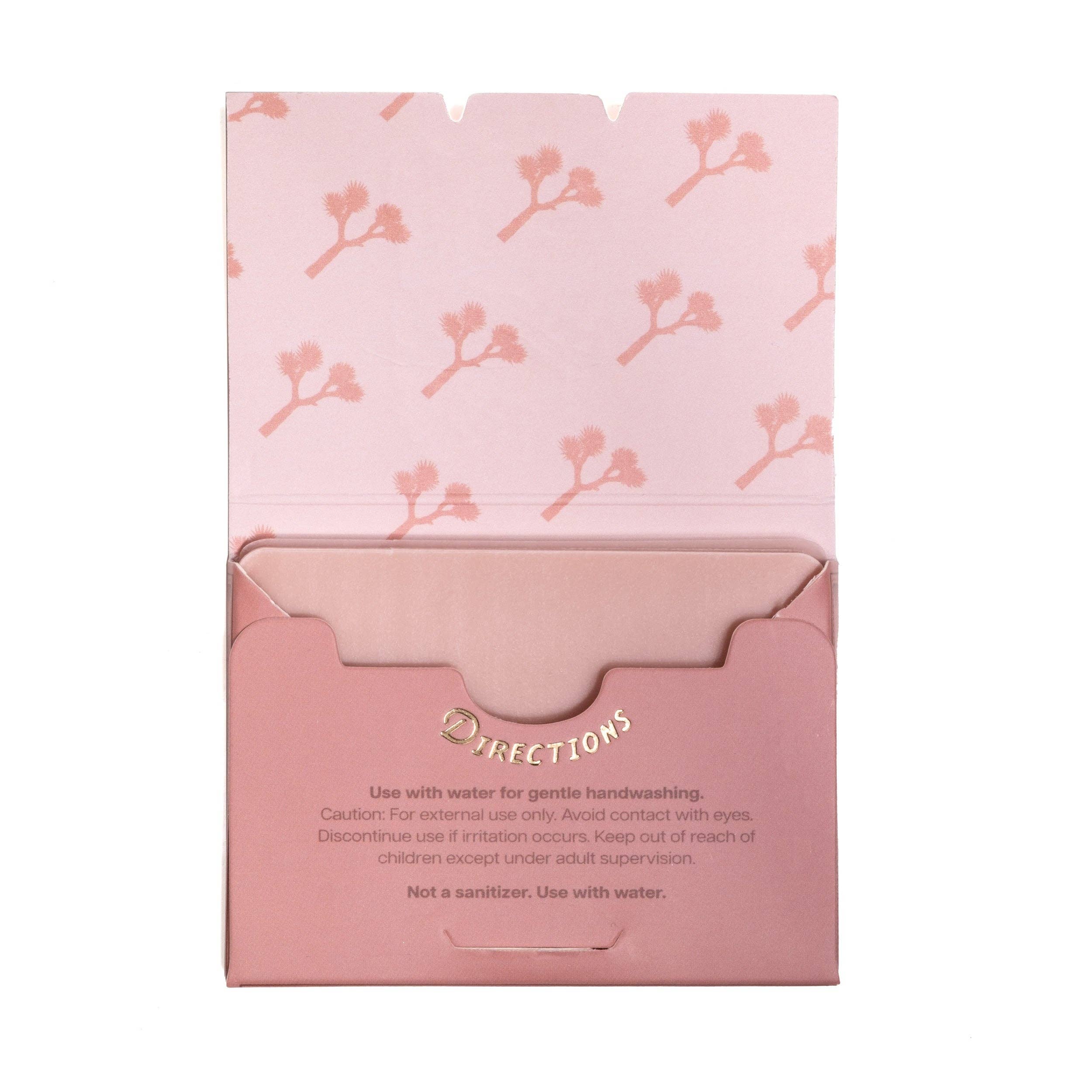 Pink packaging with floral pattern and text on a white background