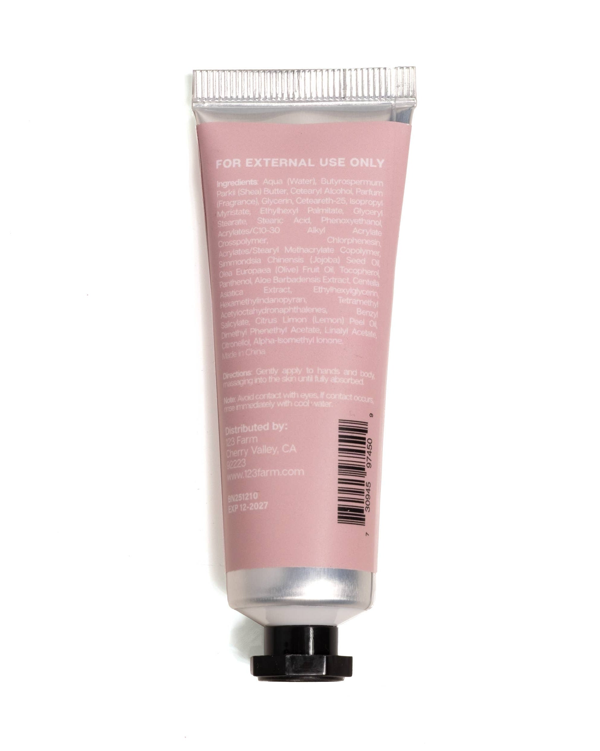 Pink tube of cream with silver cap on a white background