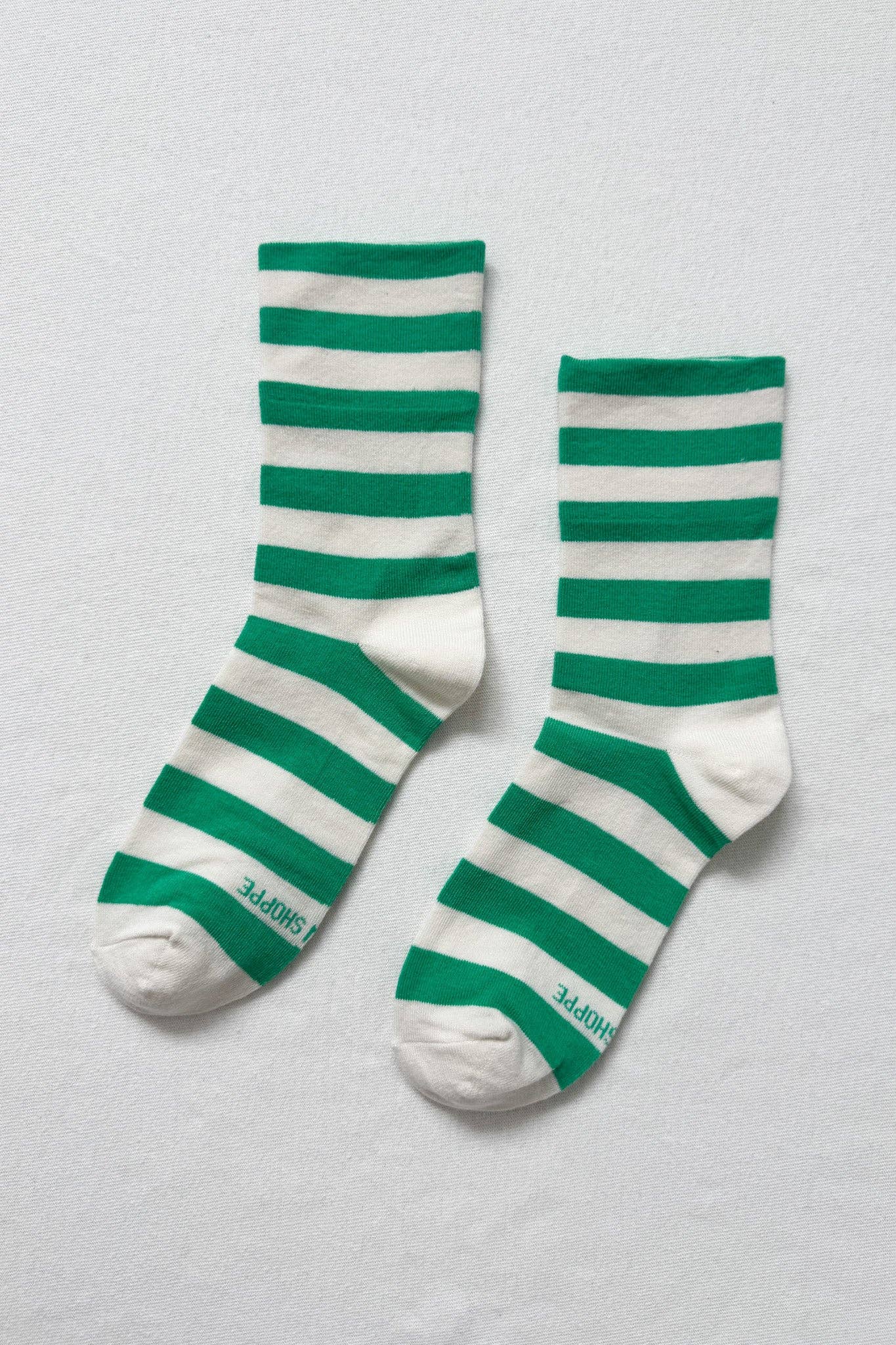 Green and white striped socks on a light gray background