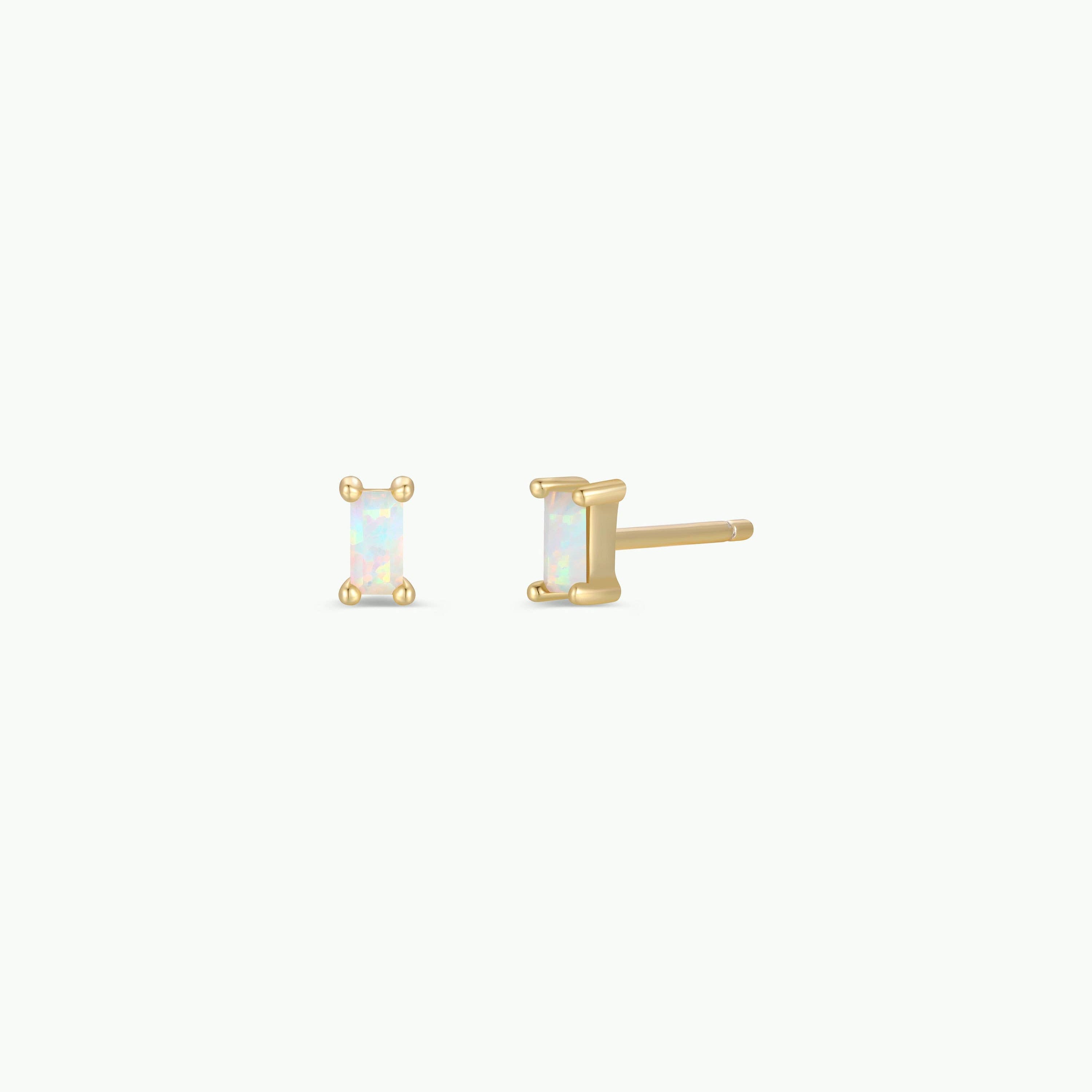 A pair of gold stud earrings with rectangular iridescent opal-like stones, shown on a plain off-white background.