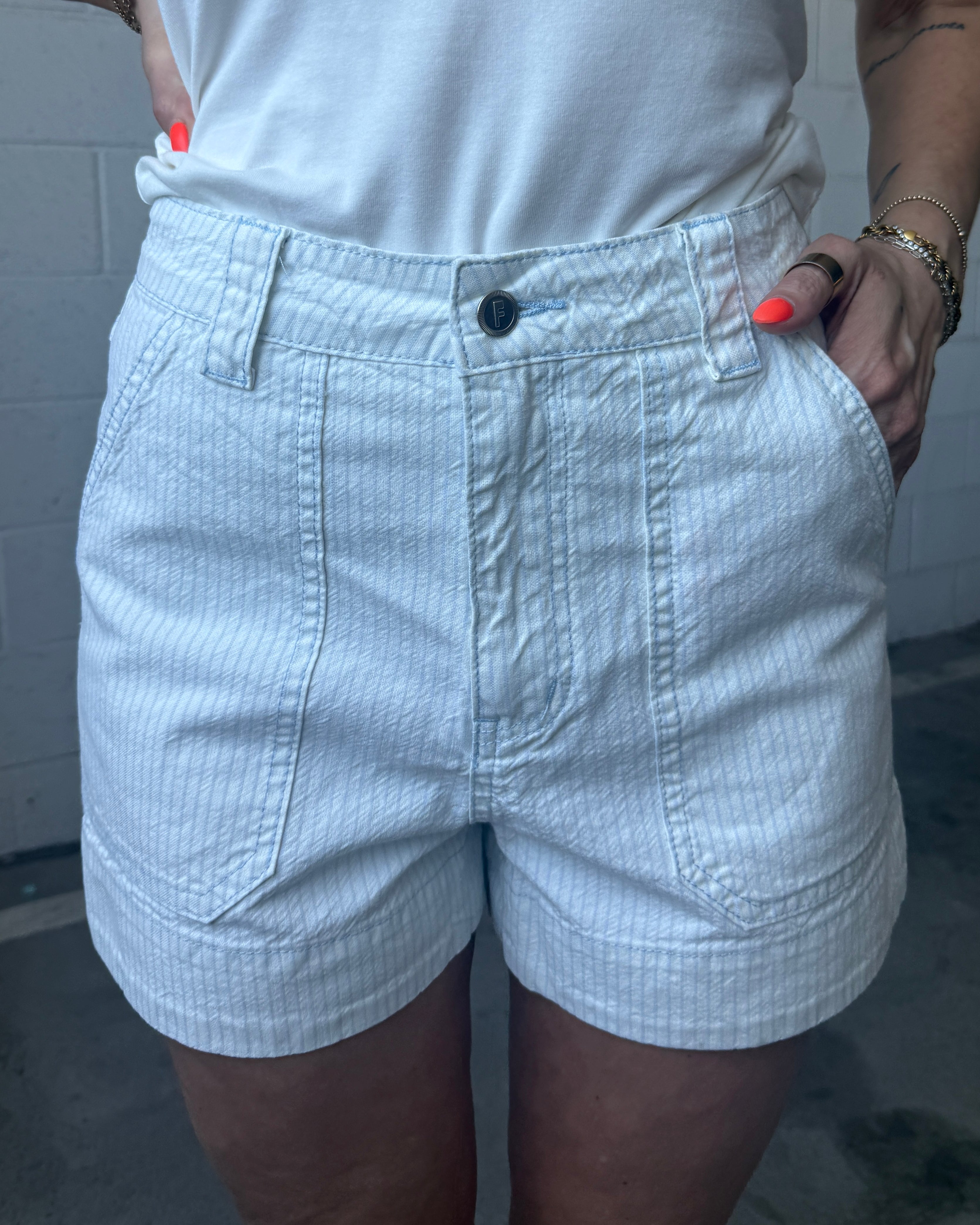 Person wearing light-colored shorts with a neutral background