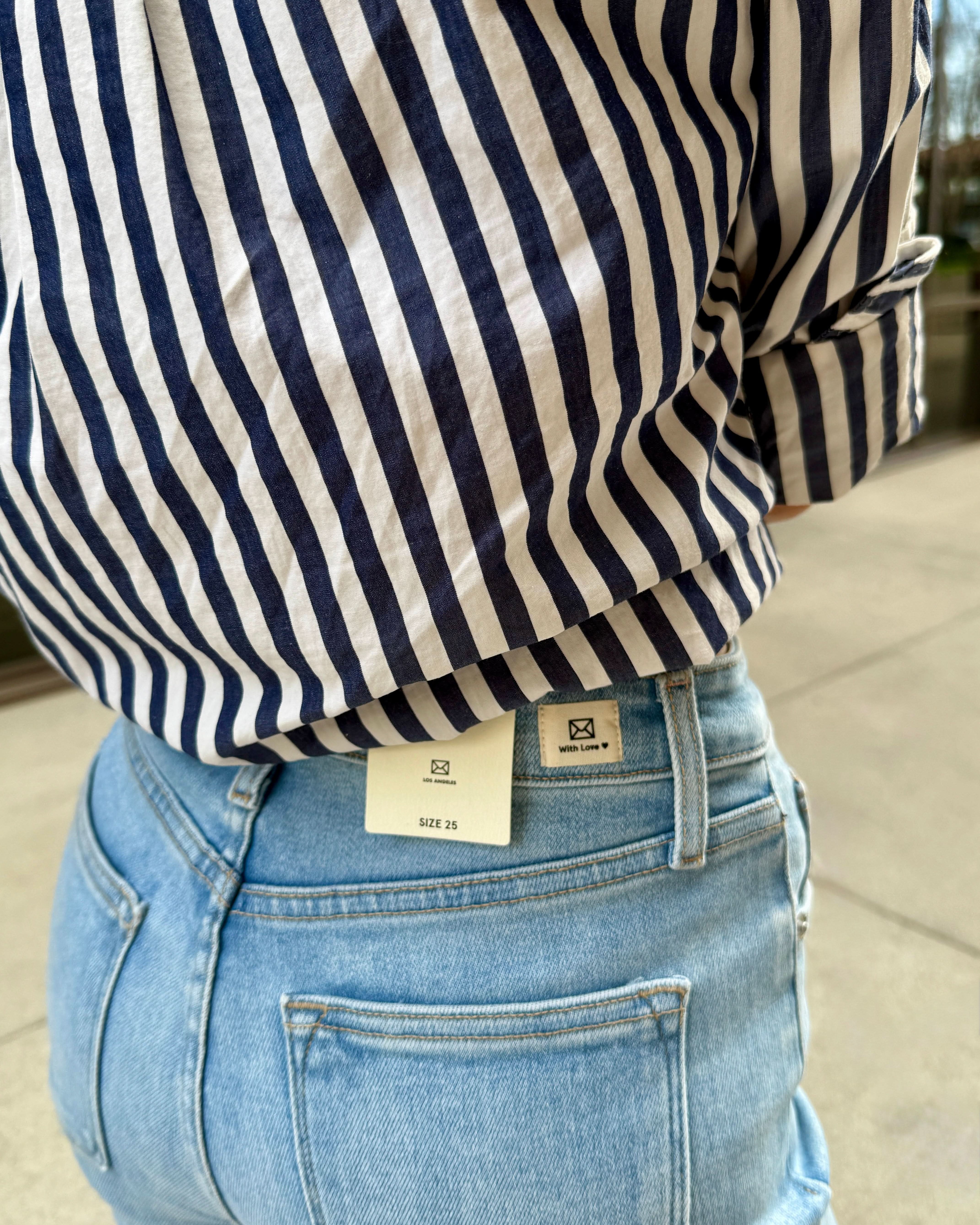 Woman wearing light wash raw hem denim game with these must-have jeans!