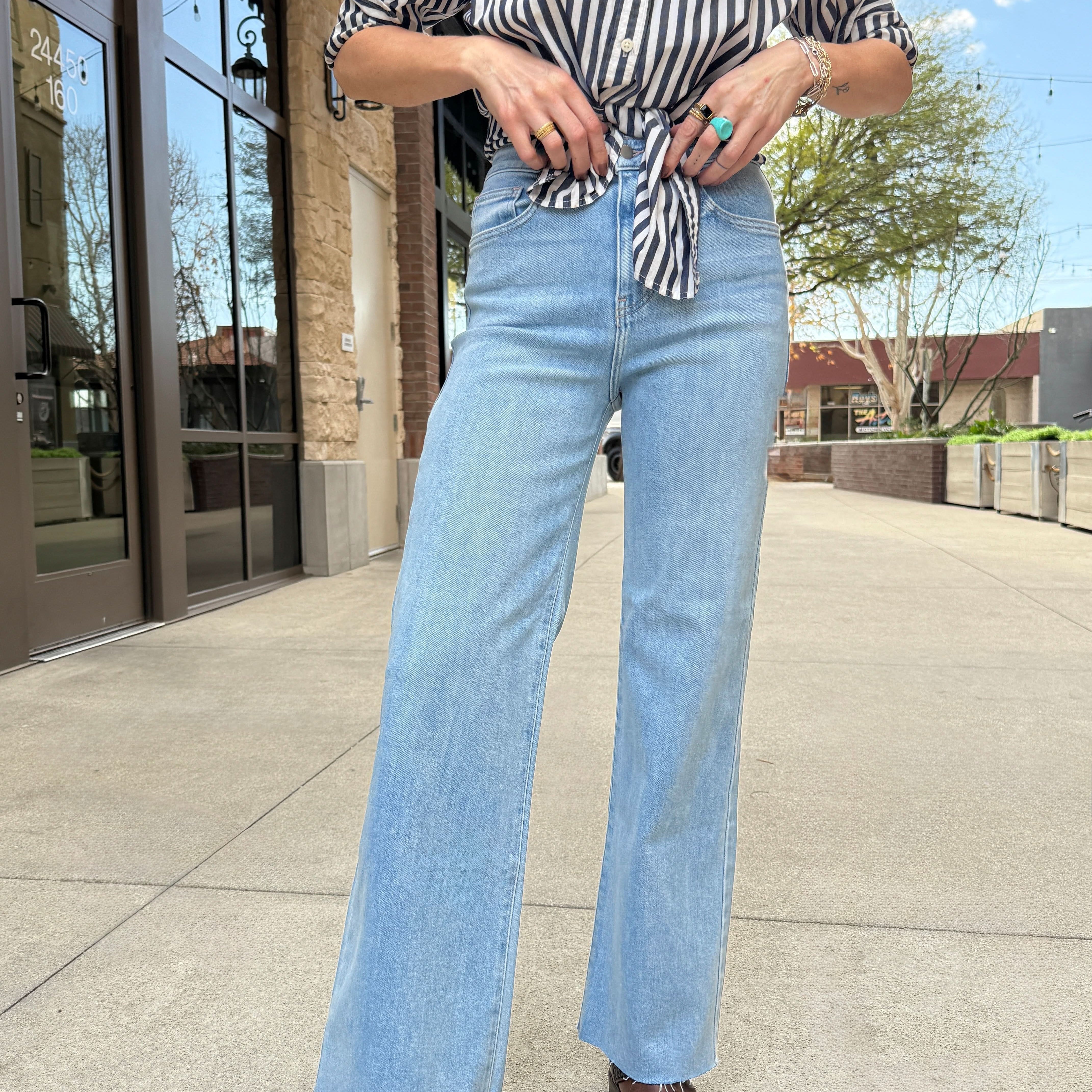 Woman wearing light wash raw hem jeans perfect blend of style and comfort with our Letter