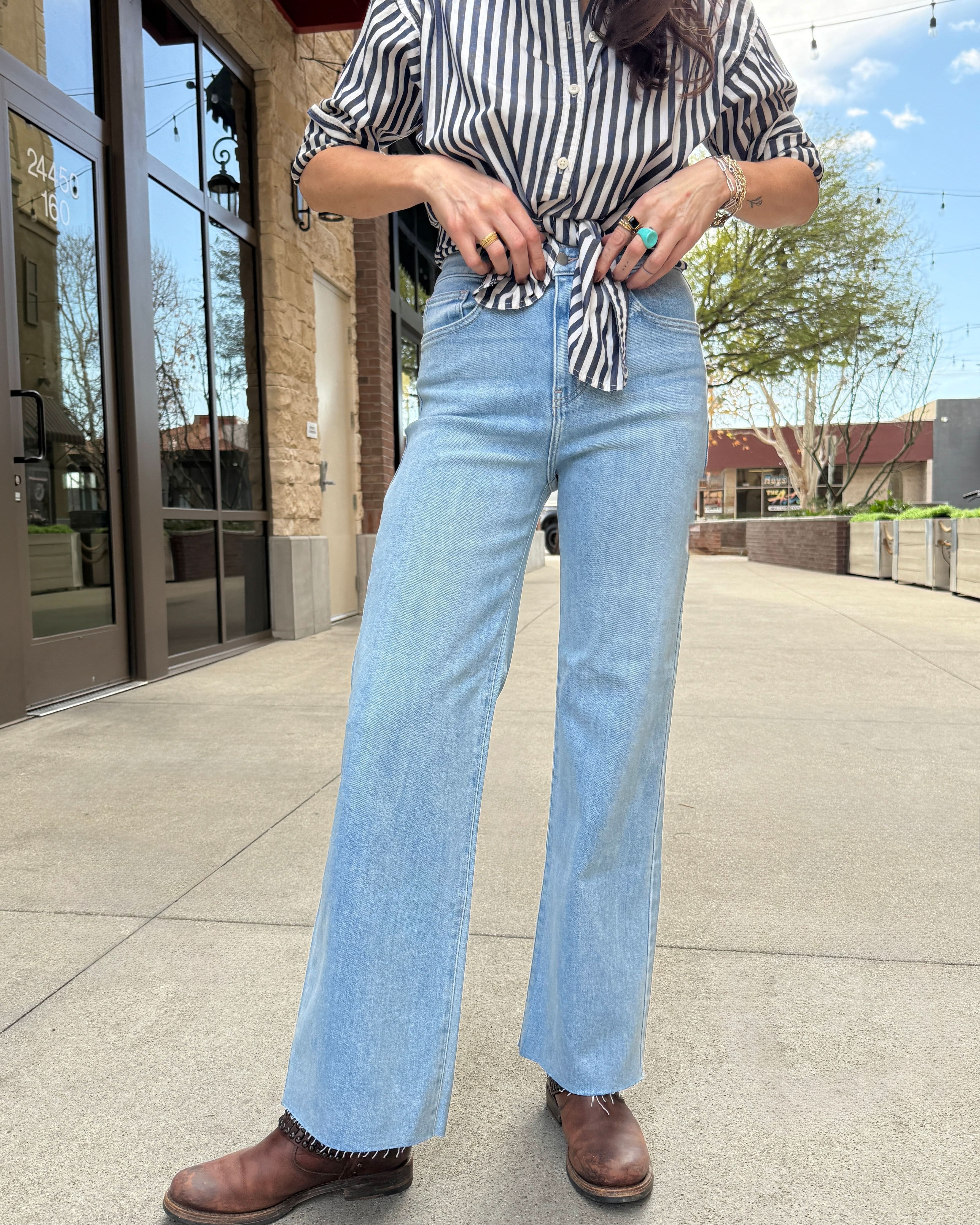 Woman wearing light wash raw hem jeans perfect blend of style and comfort with our Letter