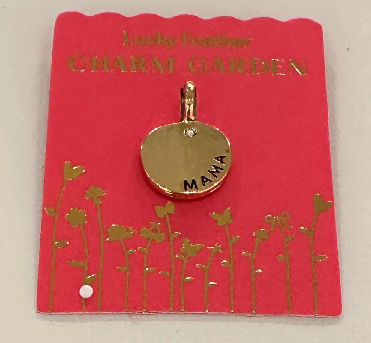 Gold charm with 'MAMA' on a red card with floral designs