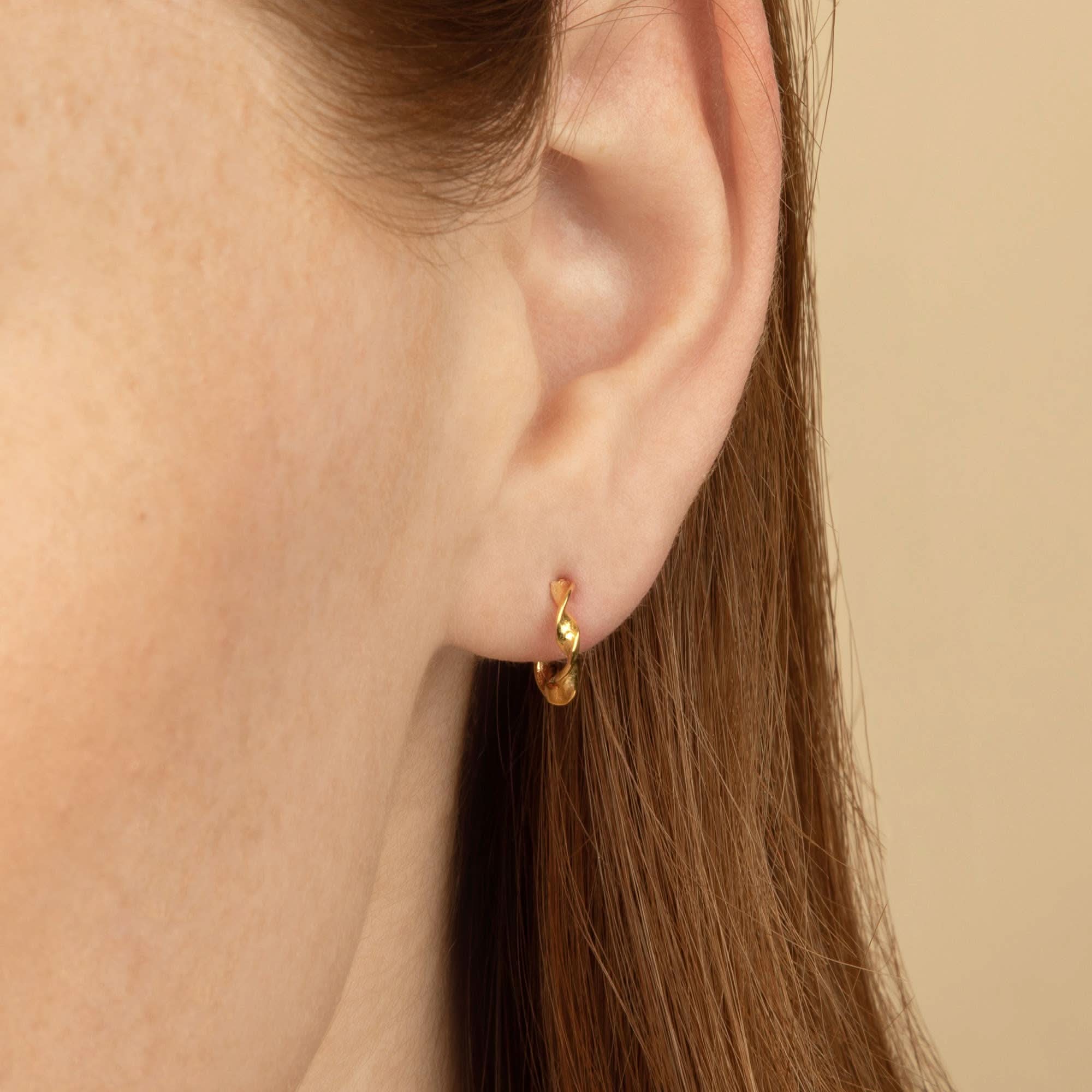 Gold hoop earring worn by a person with golden