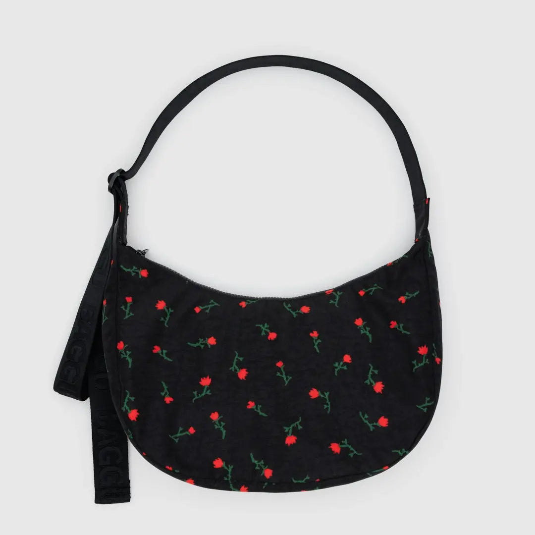 Black handbag with red floral pattern on a light gray background