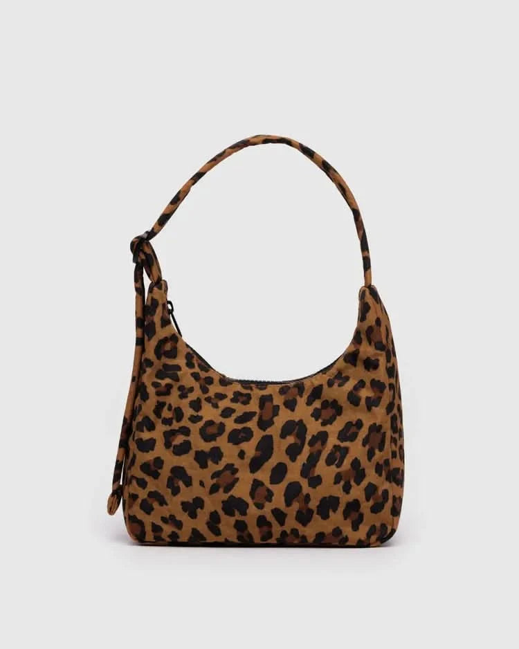 Small over the shoulder leopard purse behind a white background.