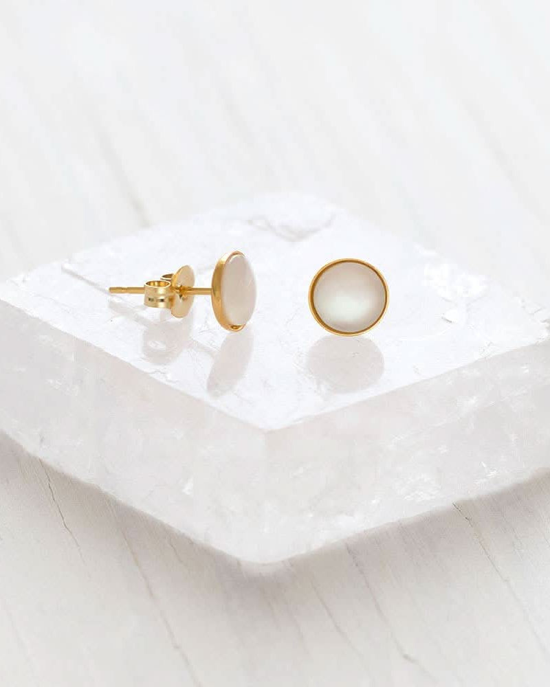 Mother of Pearl Stud Earrings Gold earrings on a white ceramic dish