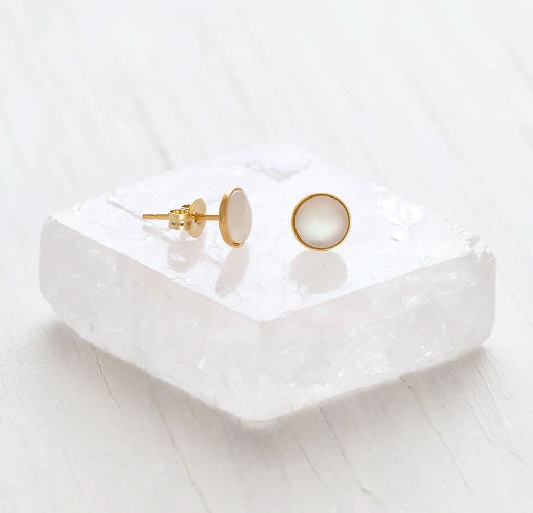 Mother of Pearl Stud Earrings Gold earrings on a white ceramic dish