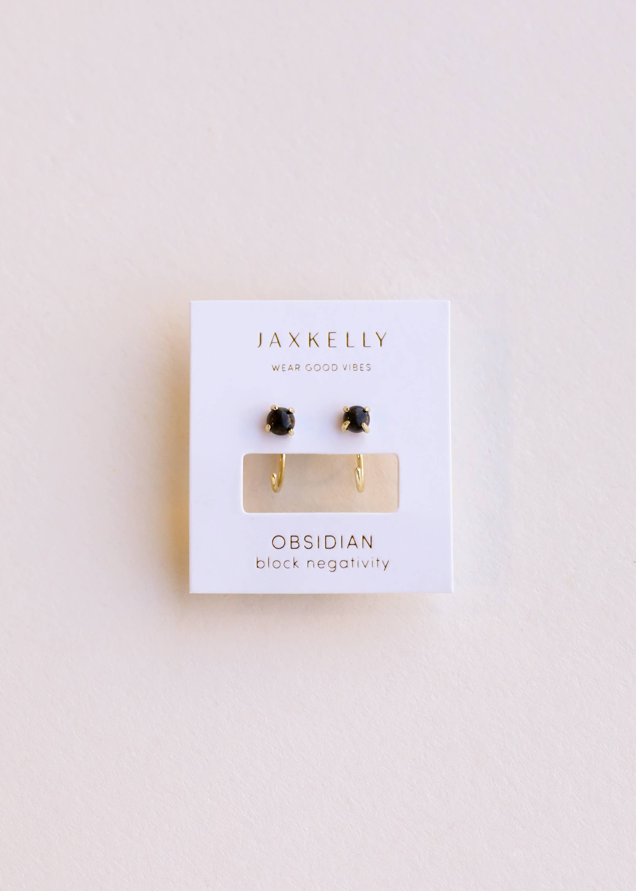 Jaxkelly obsidian earrings on a white card with a light beige background