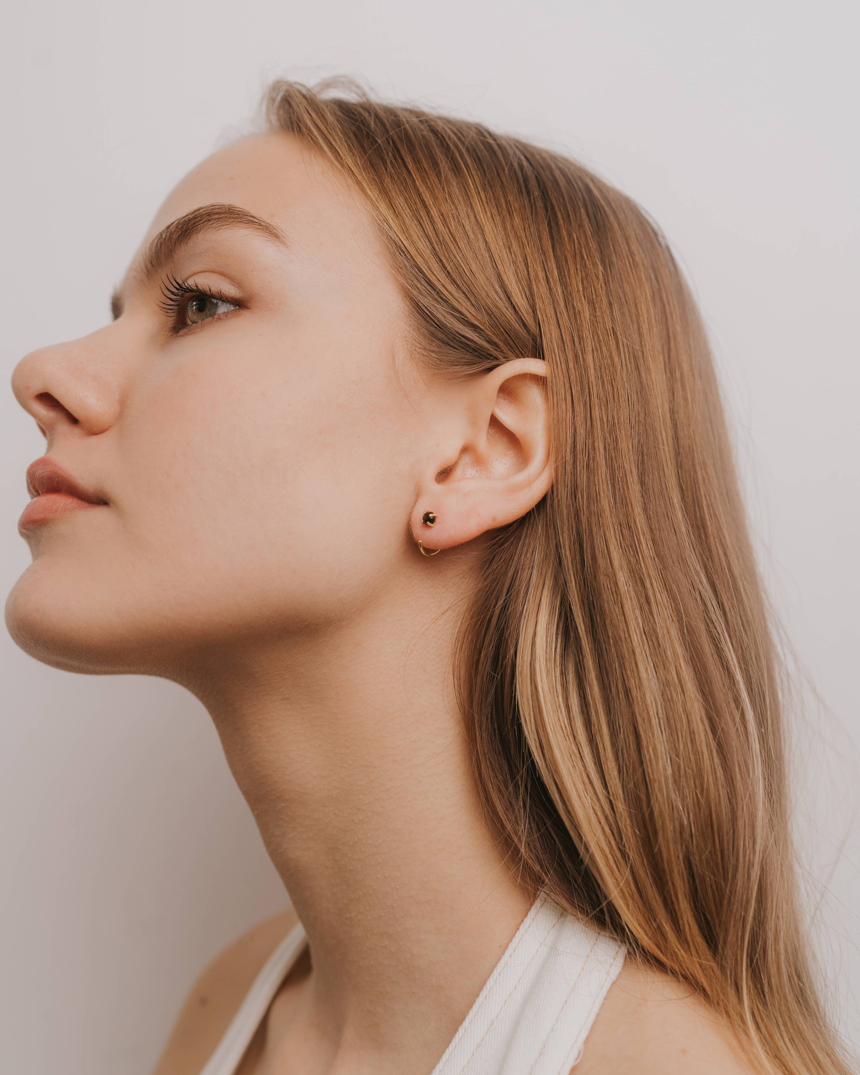Close-up of a woman's face with a neutral expression against a plain background