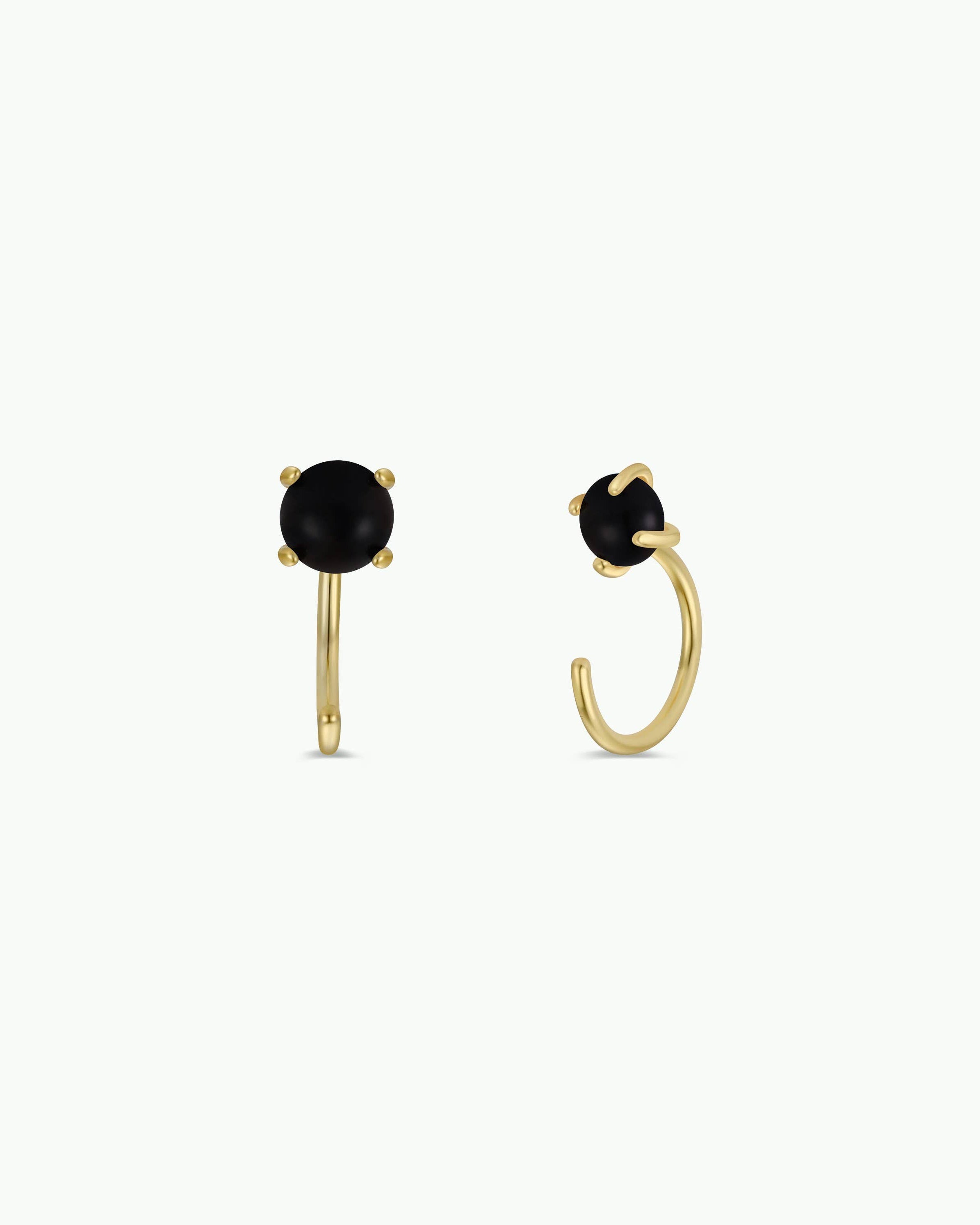 Gold hoop earrings with black gemstones on a white background