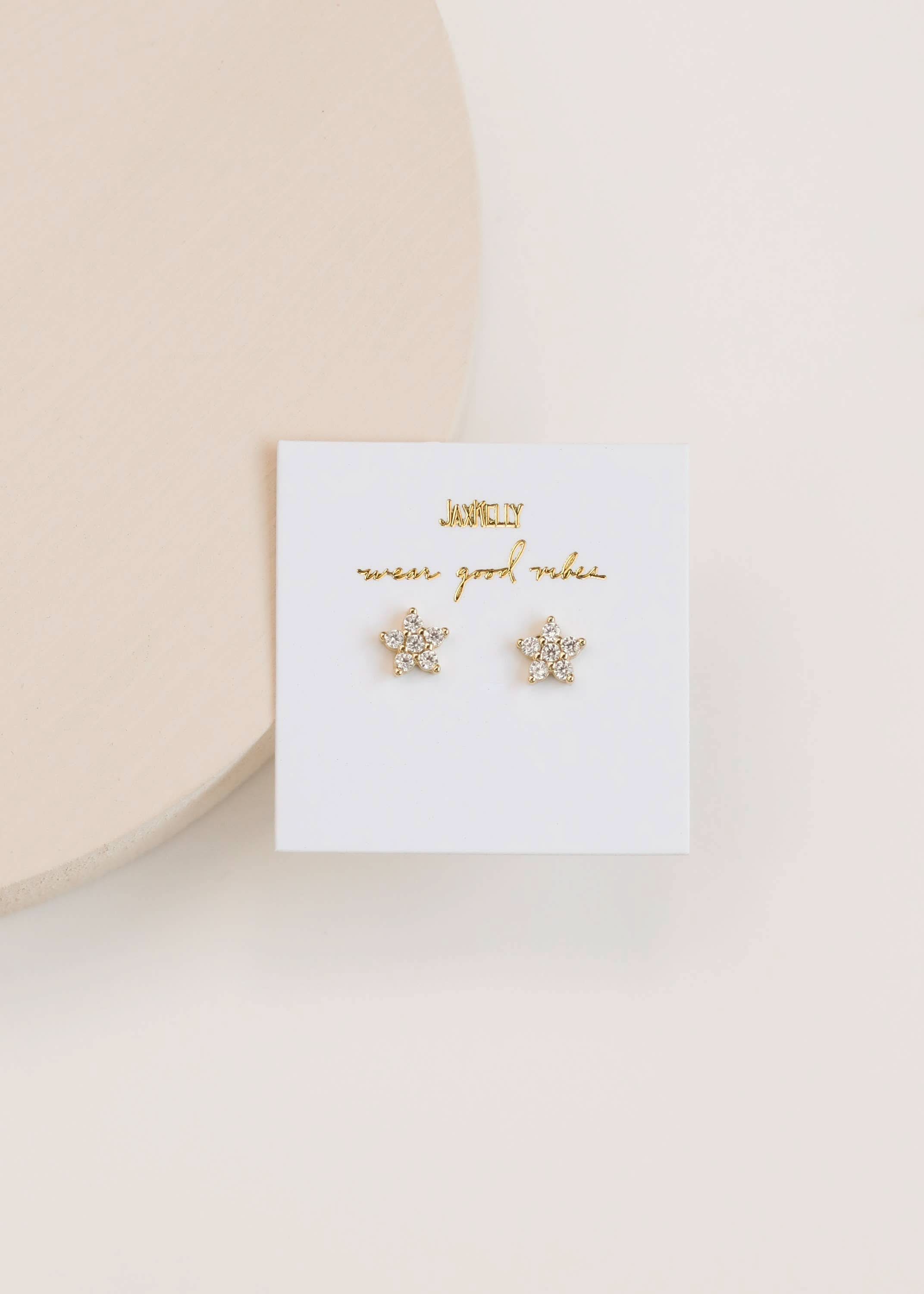 Pave Star Stud Gold Earrings holding in a white card