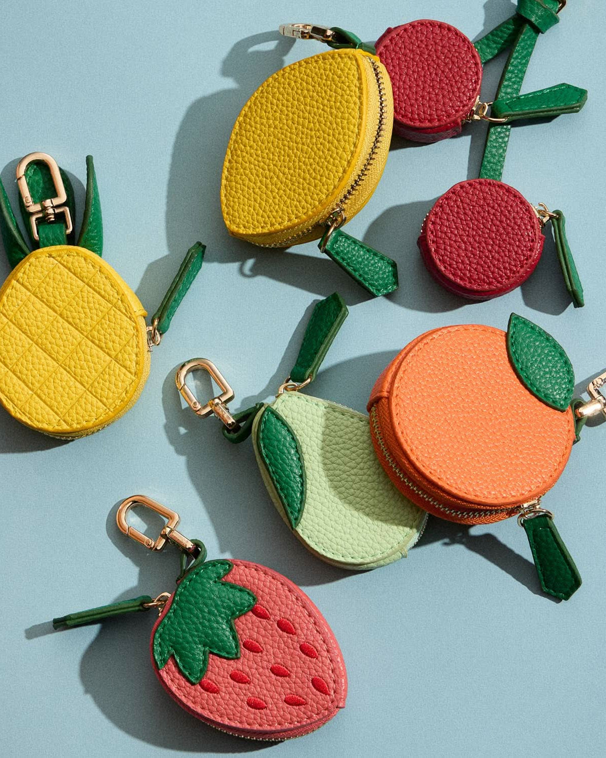 Fruit-shaped keychains on a light blue background