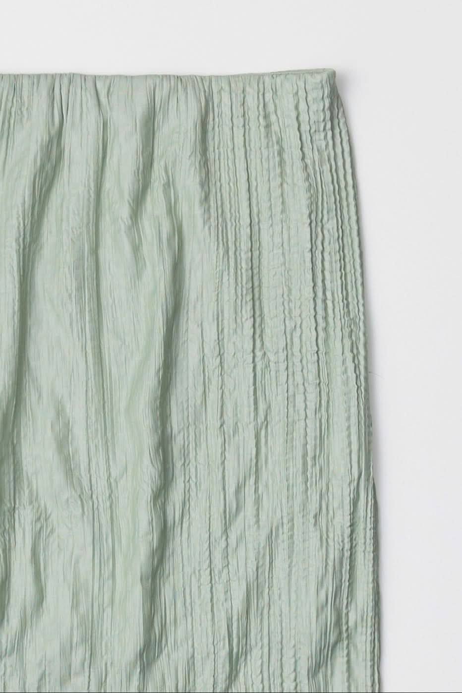 sea foam, Sage green textured skirt laid against a white surface