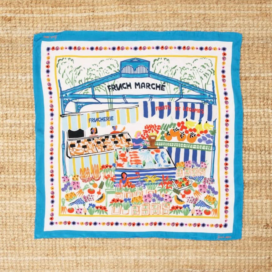 OCEANA silk scarf with blue outline and a farmers market illustration using many colors featuring bread, flower, and fruits