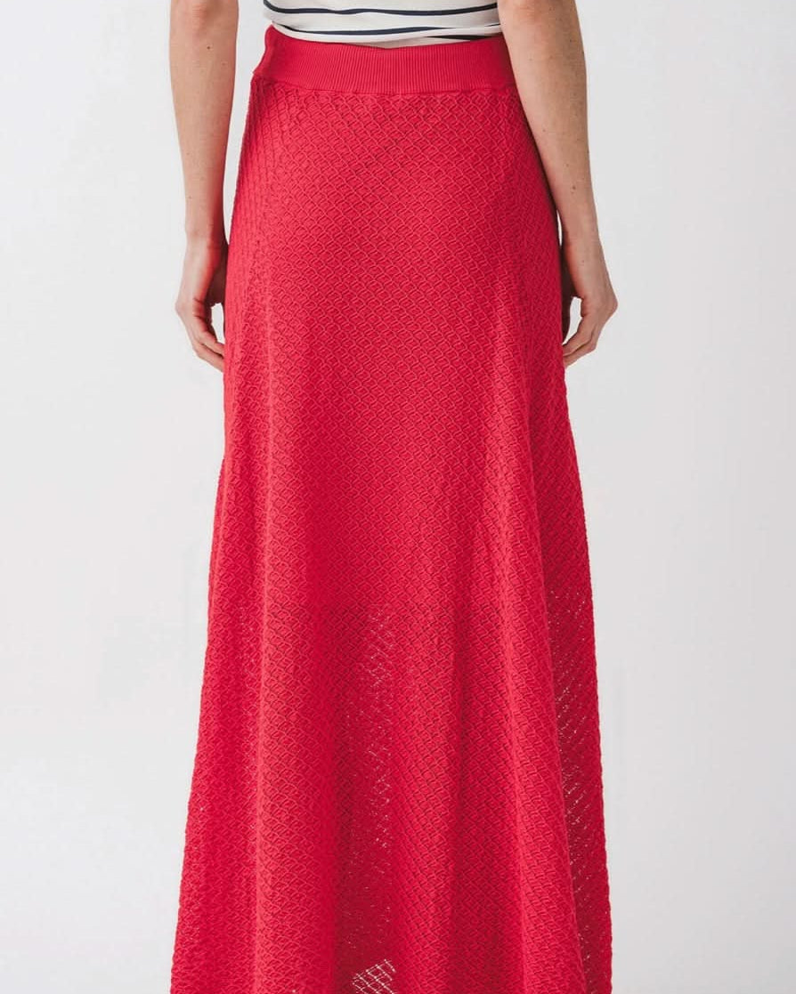 Woman facing away from the camera wearing knit red skirt with diamond geometrical pattern and front tie