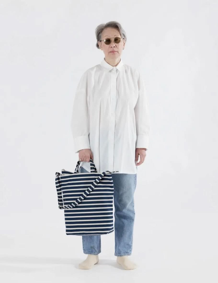 Woman carrying Blue and white horizontal striped duck bag from BAGGU
