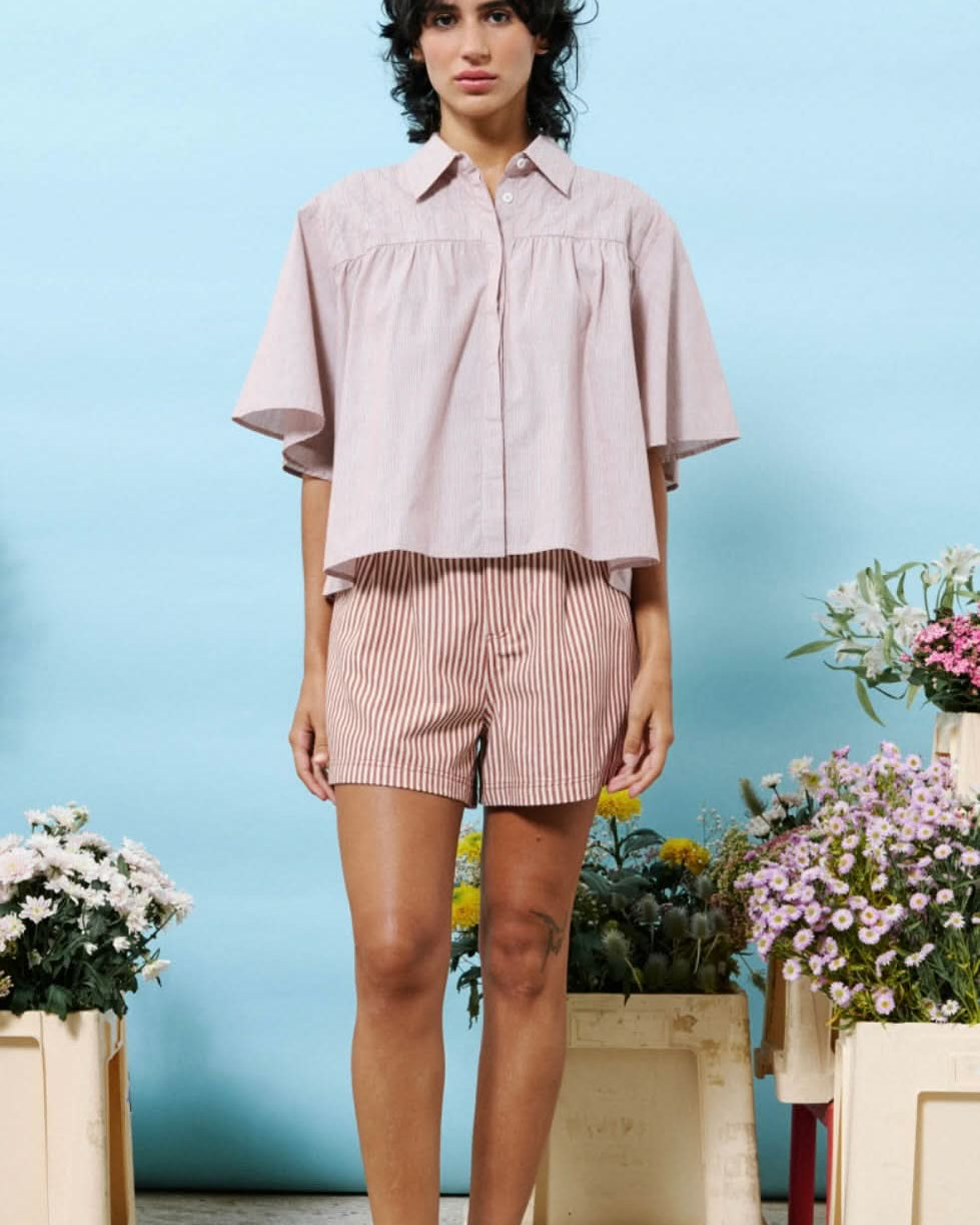 Woman wearing 100% cotton button down, cropped blouse with small vertical stripes