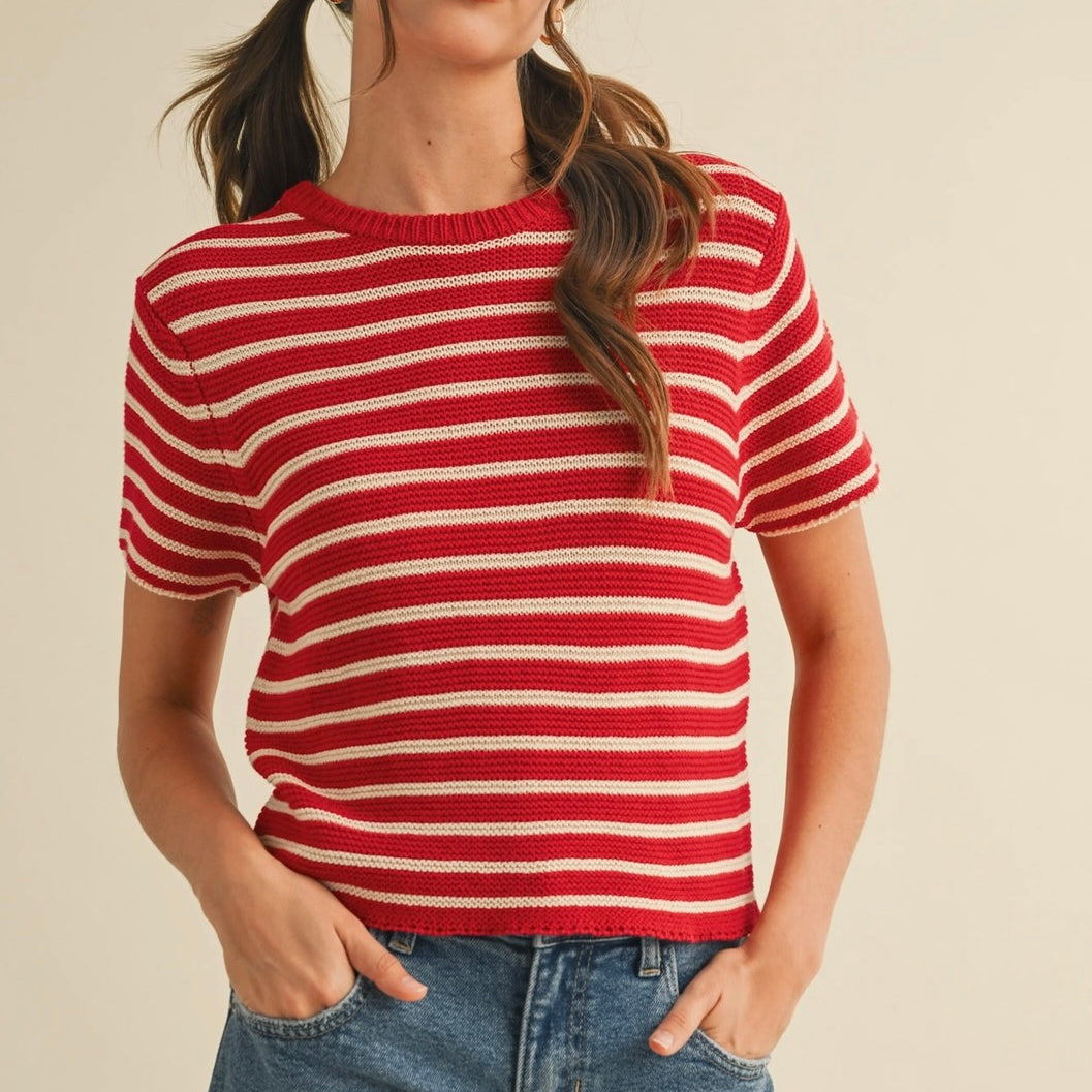 Woman wearing short sleeve red and taupe knitted sweater with jean shorts