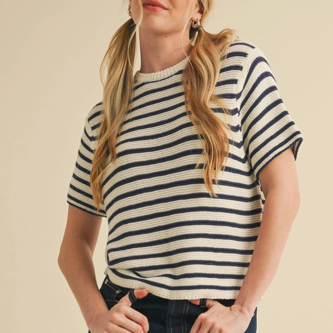 Woman wearing short sleeve knitted black and white striped sweater with dark blue short jean skirt
